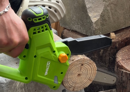 Cordless Chain Saw cutting wood outdoors